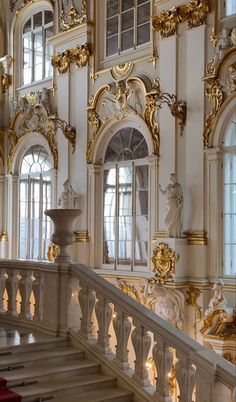 an ornate building with gold and white decorations on the walls, stairs and balconies