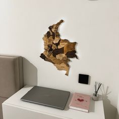 a laptop computer sitting on top of a white desk next to a wooden cutout