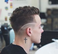 a young man with a cross tattoo on his forehead and undercut in the back