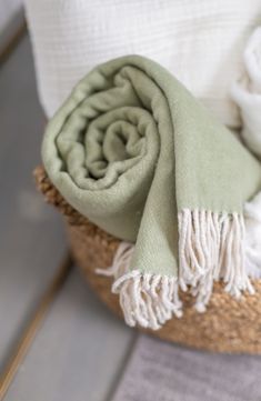 a green and white blanket sitting on top of a basket