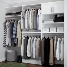 an organized closet with clothes hanging on shelves