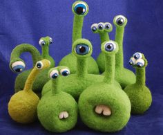 a group of green stuffed animals with googly eyes