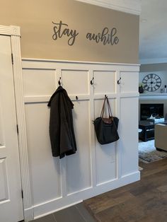 a coat rack with two coats hanging from it's hooks and the words stay awhile