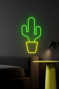 a neon green cactus sitting on top of a table next to a wall mounted clock