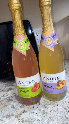 two bottles of wine sitting on top of a counter