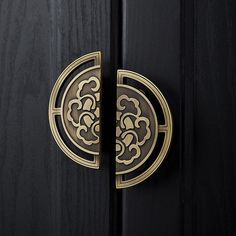 an ornate door handle on a black wooden door