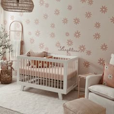 a baby's room decorated in pink and white with flowers painted on the wall