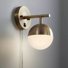 a wall light that is on the side of a wall with a lamp attached to it