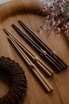 some sticks are sitting on a wooden table next to flowers and a wreath with twine