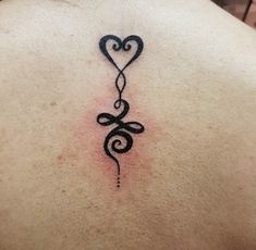 the back of a woman's neck with a tattoo in the shape of a heart