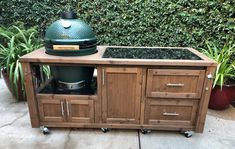 a big green egg sitting on top of a wooden cabinet