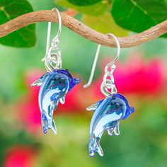 Just as these cute dolphins guide the ocean with their wise and carefree attitude, they will lead your style with a magical and enchanting touch. Thai artisan Panapai works with meticulous handblown techniques to create these dolphin-shaped glass dangle earrings, bewitchingly adorned with blue pigments as a symbol of fantasy. As a comfortable touch, sterling silver hooks complete the design. Cute Dolphins, Blue Dolphin, Blue Pigment, Hand Blown Glass, Dolphins, The Ocean, Jewelry Earrings Dangle, Premium Quality, Dangle Earrings