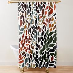 a shower curtain with leaves on it in brown, orange and green colors is shown