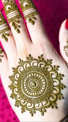 a woman's hand with henna tattoos on it