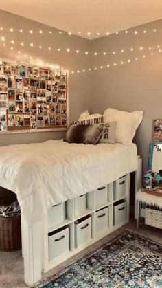 a white bed sitting in a bedroom next to a wall covered in pictures and lights