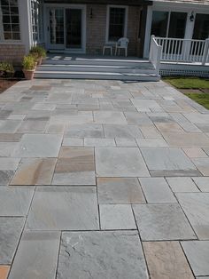 an outdoor patio with flagstone pavers and steps leading to the back porch area