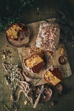 two pieces of cake sitting on top of a wooden cutting board next to other items