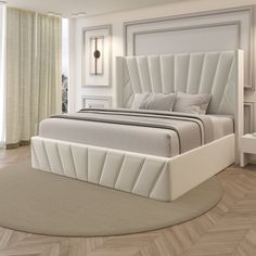 a large white bed sitting on top of a wooden floor