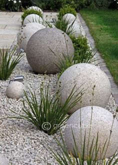 some very pretty rocks and plants by the sidewalk