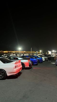 several cars parked in a parking lot at night