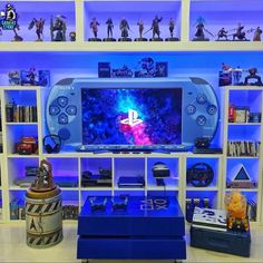 a video game console sitting on top of a table next to a shelf filled with figurines