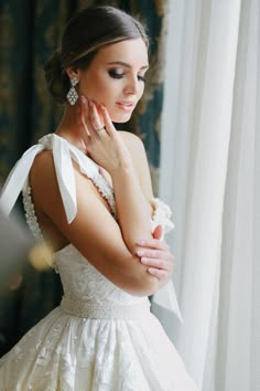 a woman in a wedding dress looking at herself