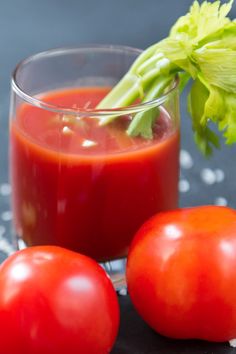 two tomatoes and a glass of tomato juice