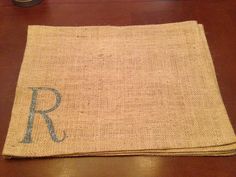 a burlocked placemat with the letter r on it sitting on a wooden table