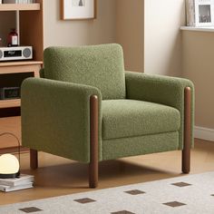 a green chair sitting in front of a window next to a book shelf and lamp