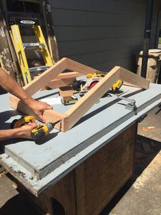 a man is using a drill to attach the top of a piece of plywood