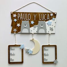 a wooden sign hanging from the side of a wall next to two frames with pictures on them