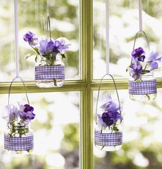 purple flowers are hanging from the window sill