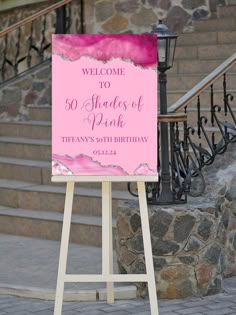 a welcome sign stands in front of some stairs and steps with pink paint on it