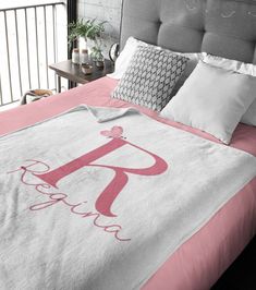 a bed with a pink and white comforter on it