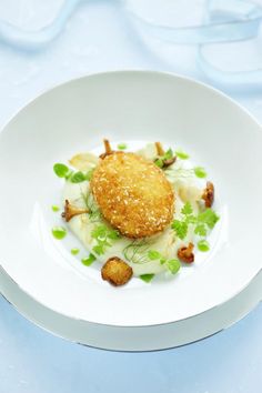 a white plate topped with food on top of a blue table cloth covered in water