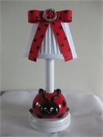 a red and white lamp with a ladybug on it