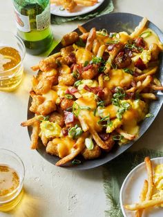 a plate full of cheesy fries and beer