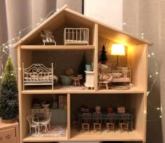 a doll house with furniture and lights on the inside is shown in front of a curtained window