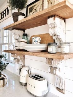 a kitchen shelf filled with lots of dishes on top of white counter tops next to pots and pans