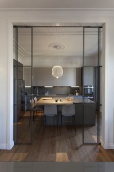 an open kitchen and dining room with sliding glass doors on the wall to let in light