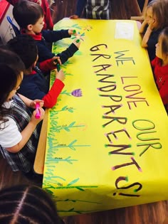 children sitting at a table with a large yellow sign