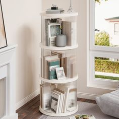 a white corner shelf with books on it in a living room next to a window