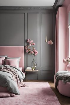 a bedroom with pink and grey walls, bedding, rugs and pillows on the floor