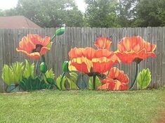 a painting of orange flowers painted on the side of a fence