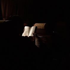 the person is reading a book in the dark