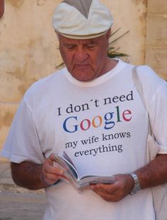 an older man reading a book while wearing a t - shirt that says i don't need google my wife knows everything