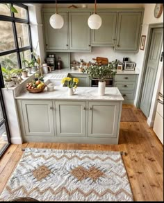 a kitchen with green cabinets and an area rug in front of the counter top that has yellow flowers on it