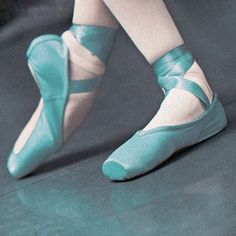 a woman's feet in blue ballet shoes