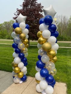 two tall blue and white balloons are on the sidewalk