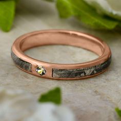 a rose gold wedding band with mossy wood inlays and a single diamond